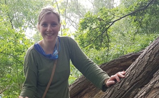 Hier ist Lizzy zu sehen wie sie aus einem halb eingeschneiten dunkelgrünen Zelt lachend herausschaut